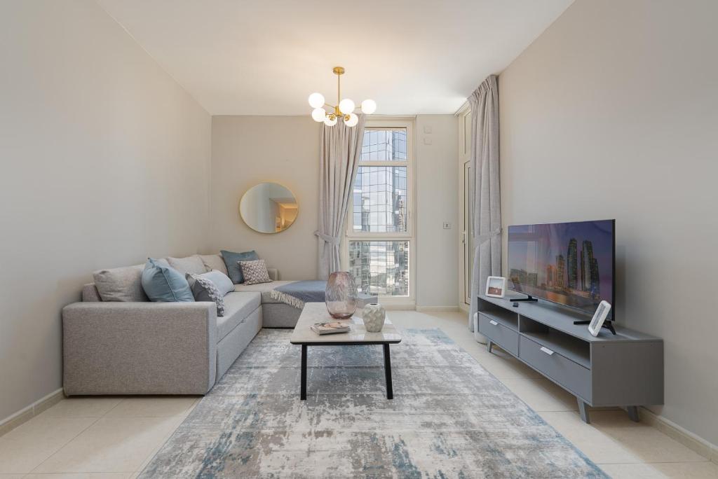 a living room with a couch and a tv at Urban Chic - Mangrove Place in Abu Dhabi