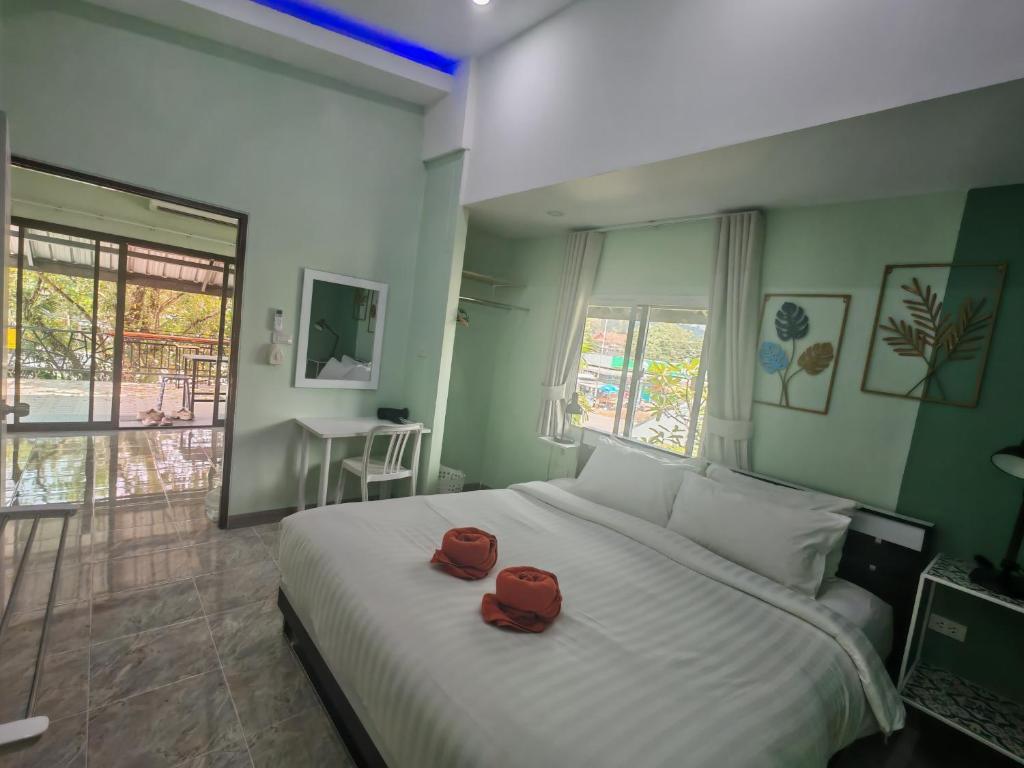 - une chambre avec un lit doté de deux chapeaux rouges dans l'établissement Nemo 2 Resort, à Ao Nang Beach