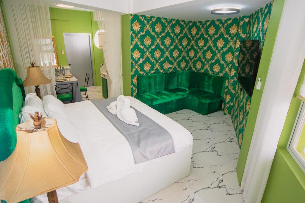 a hotel room with a bed and a green couch at The Stackey Hotel in Olongapo
