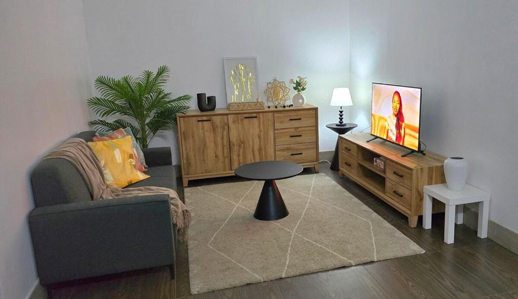 a living room with a couch and a tv and a table at Cosy Homes in Suva - 2BR Family Unit in Suva