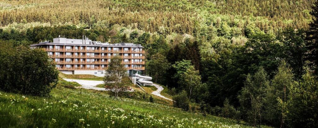 um grande edifício no meio de uma floresta em Radisson Hotel Szklarska Poręba em Szklarska Poręba