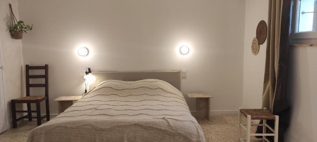 Un dormitorio con una cama con dos sillas y dos lámparas. en Le laurier, en Bourg-Saint-Andéol