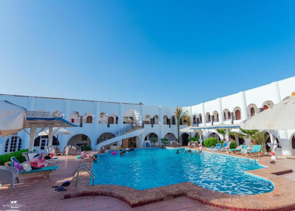 a large pool in a building with people sitting around it at yasmina hotel in Dahab