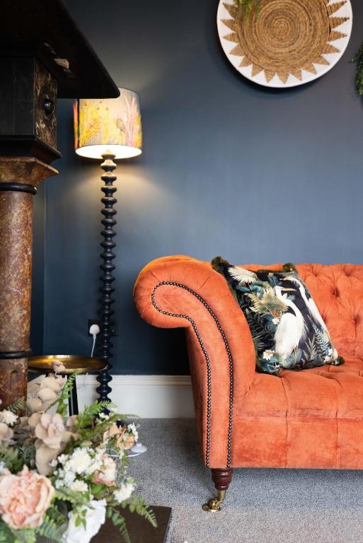 a living room with an orange couch and a lamp at Battersea Boutique Apartments in Bangor