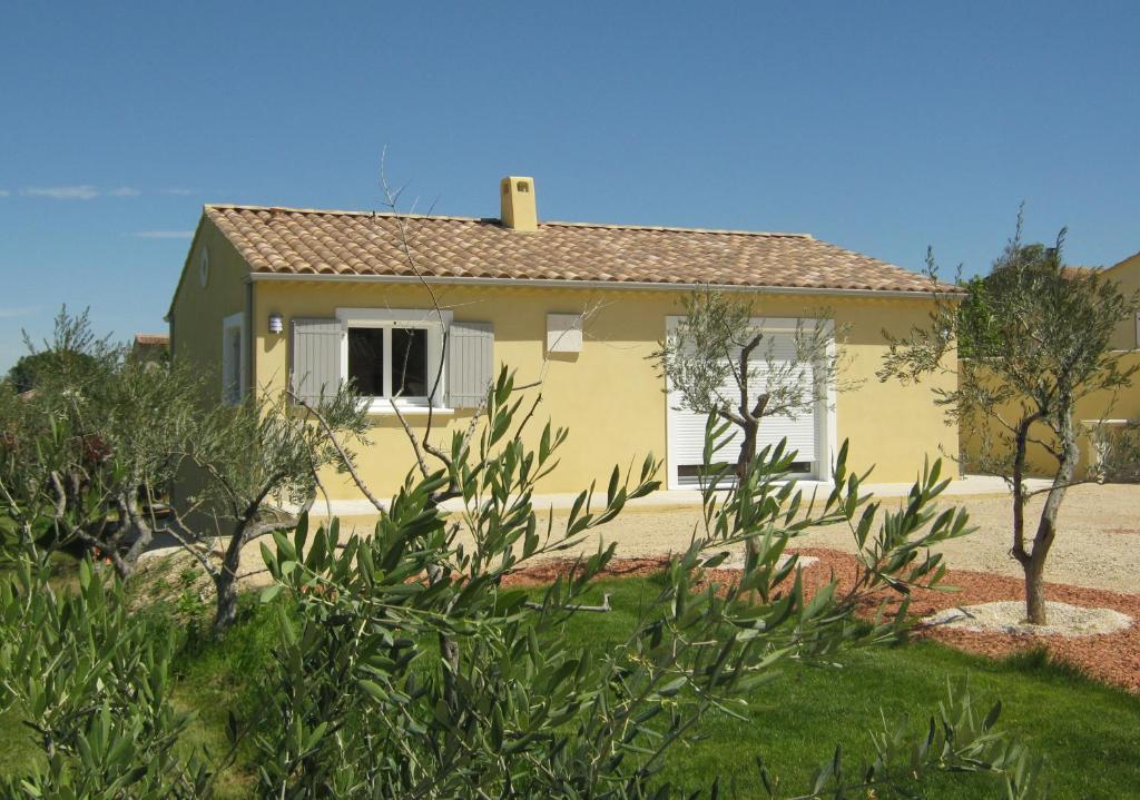 a small yellow house with a roof at Le Jardin des Tourterelles in Robion en Luberon