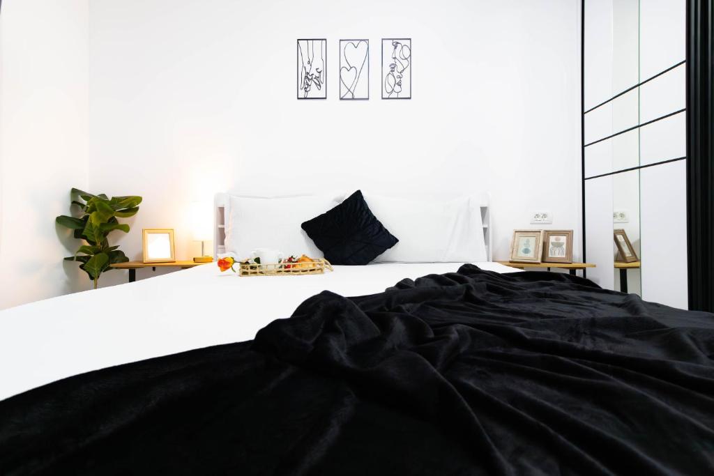 Popeşti-LeordeniにあるAmaria Sunsetのベッドに黒い毛布が掛けられた白い寝室