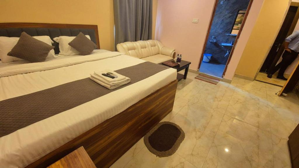 a hotel room with two beds and a chair at Hotel Plaza in Chunchura