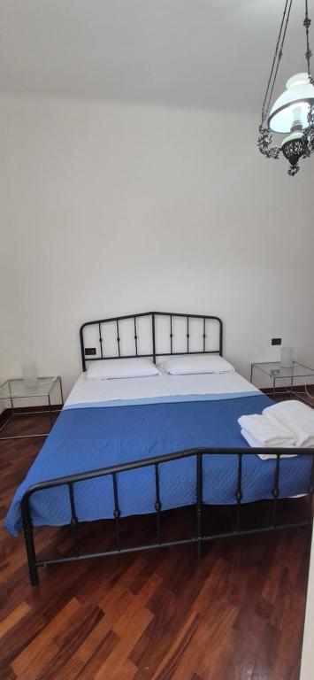 a bedroom with a bed with a blue blanket at San Vincenzo C Rooms in Genoa