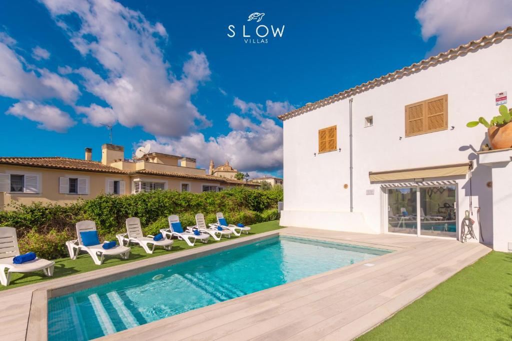 une villa avec piscine et chaises longues dans l'établissement Villa Can Benet de sa Cubana by Slow Villas, à Calvià