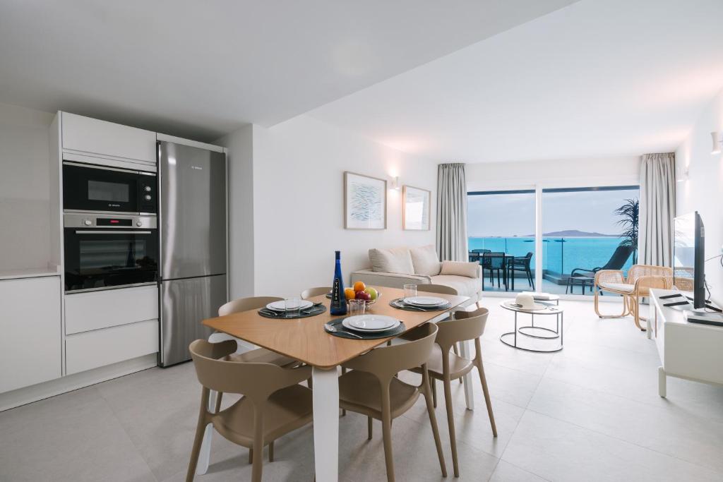eine Küche und ein Wohnzimmer mit Tisch und Stühlen in der Unterkunft Blue Balcony Suites by Airnest in Melenara