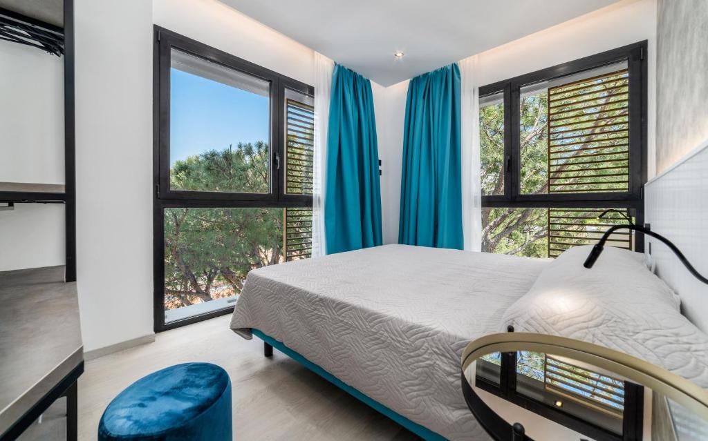 a bedroom with a bed and two windows at Residence Cala Vela Tower in Riccione