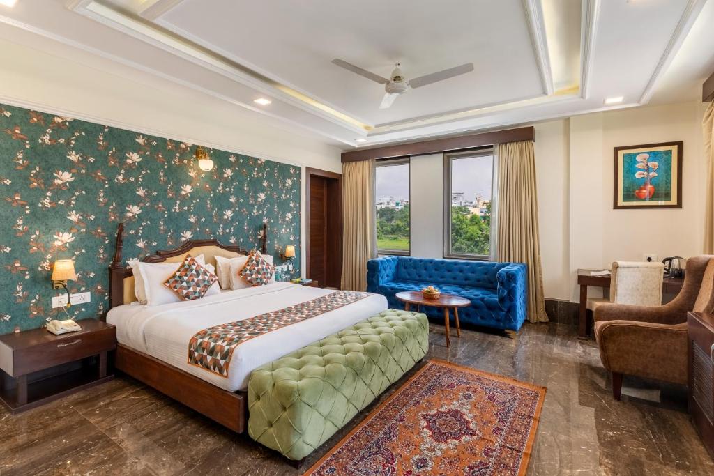 Un dormitorio con una cama, un sofá y una silla. en The Colonial - A Lake View Hotel in Udaipur, en Udaipur