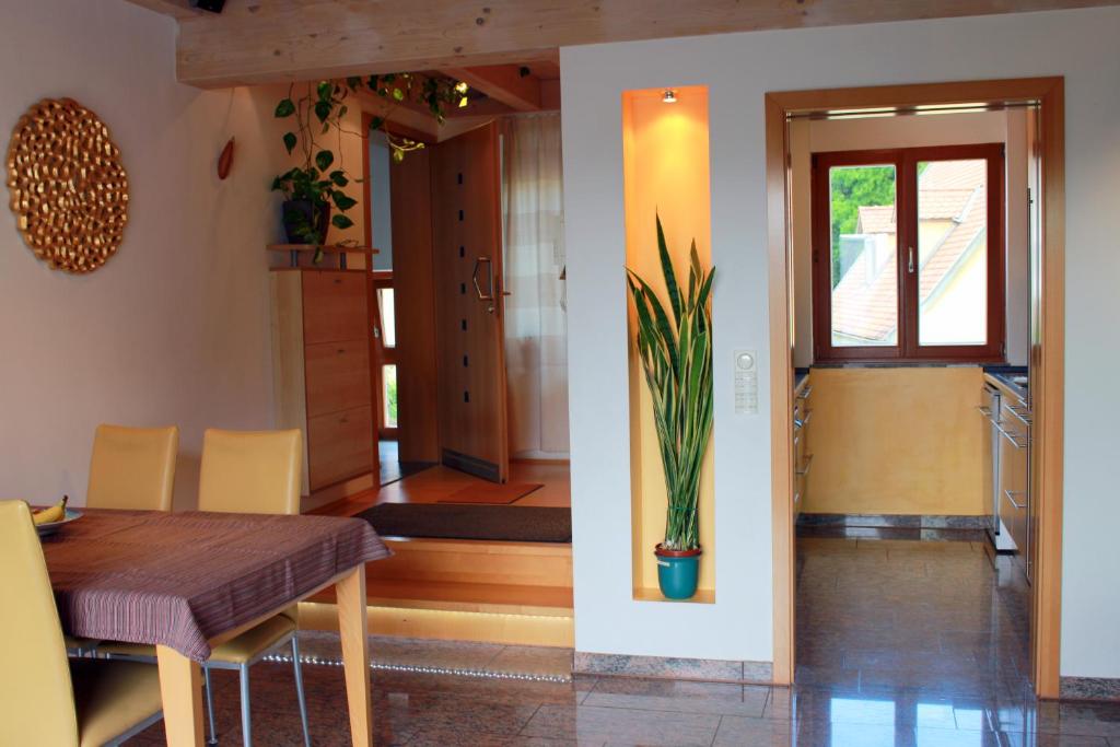 une salle à manger avec une table et une plante en pot dans l'établissement Studio A Am Burgberg, à Erlangen