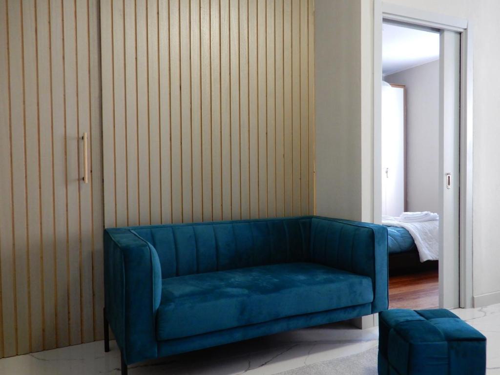 a blue couch in a room with a bedroom at Casa Valentino - Stay in the heart of Asti in Asti