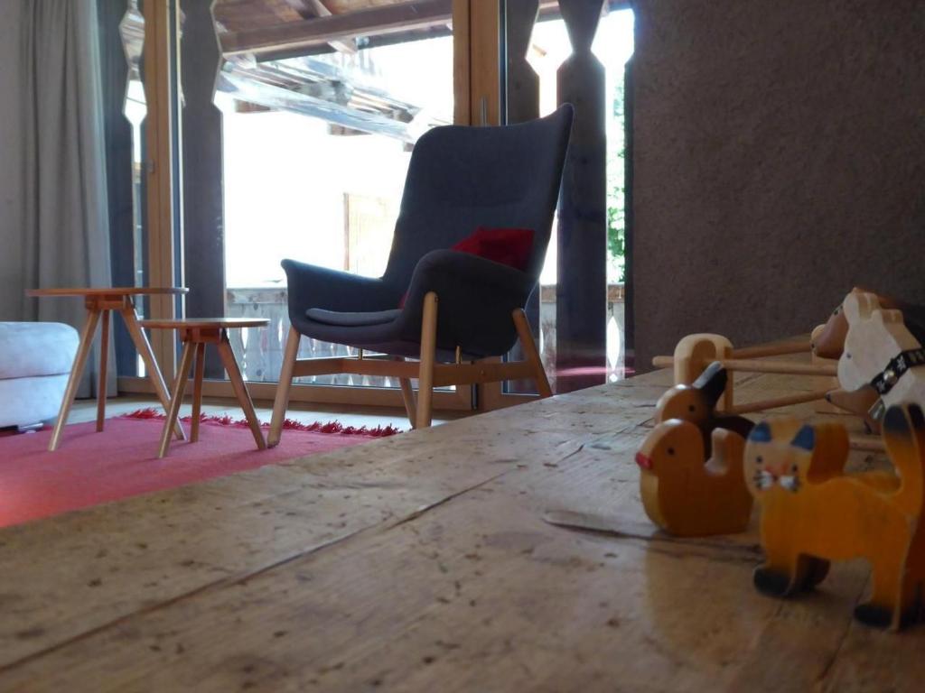 a room with a table and a chair and toys at Biala Biobergün in Bergün