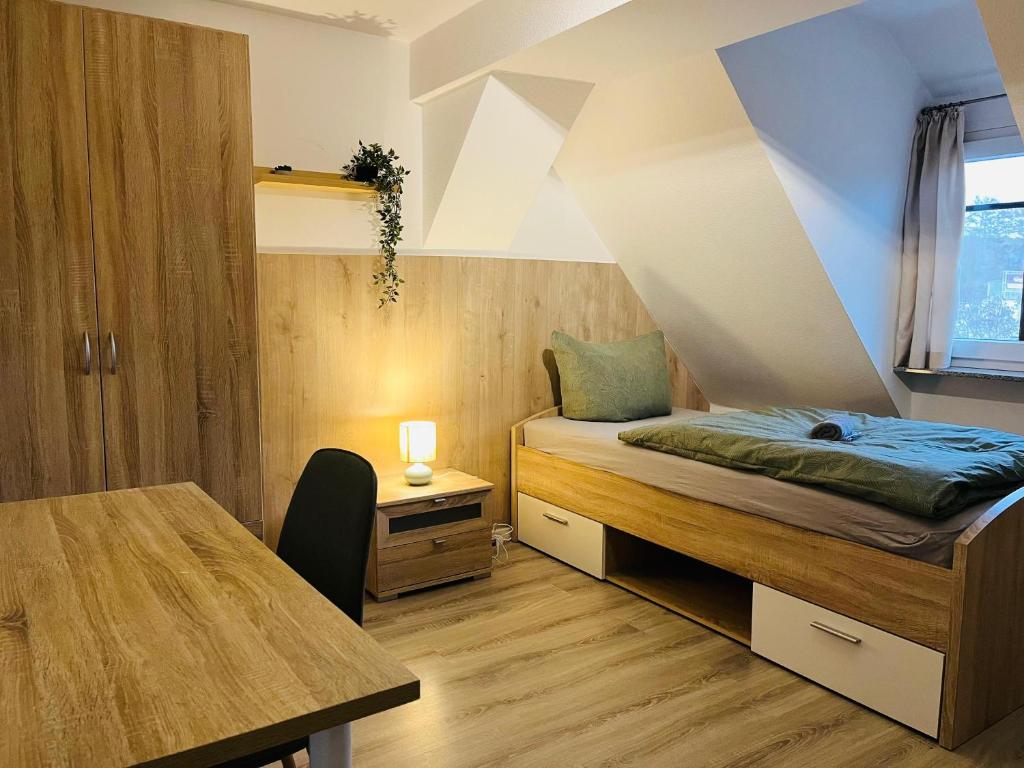 a small bedroom with a bed and a table at Seebachstuben - Dechsendorf in Erlangen