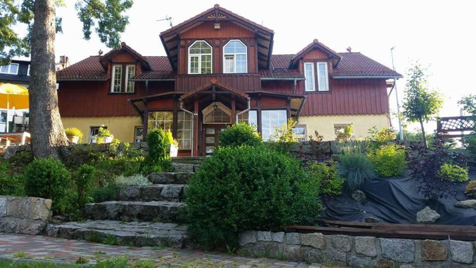 ein großes Haus mit einer Treppe davor in der Unterkunft Gosciniec Poezja in Szklarska Poręba
