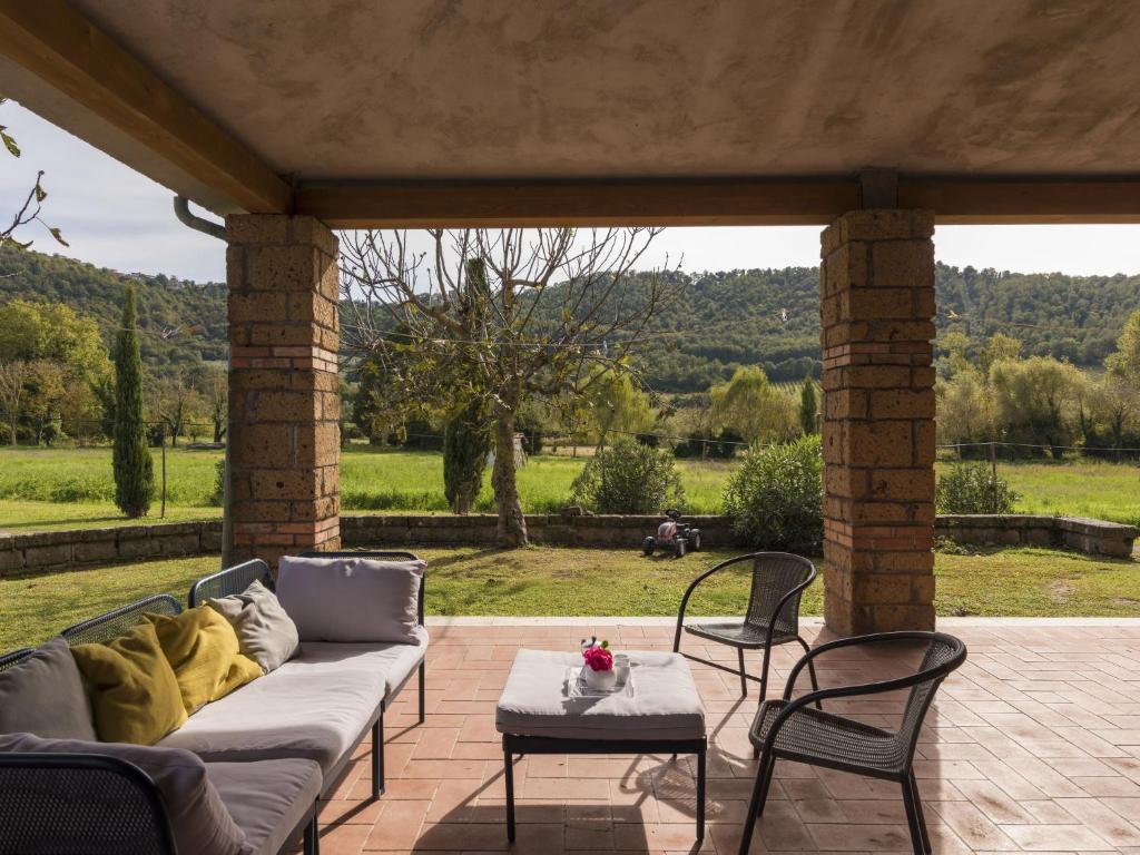 a couch on a patio with chairs and a table at Apartment Casa Domenico 2 by Interhome in Montefiascone