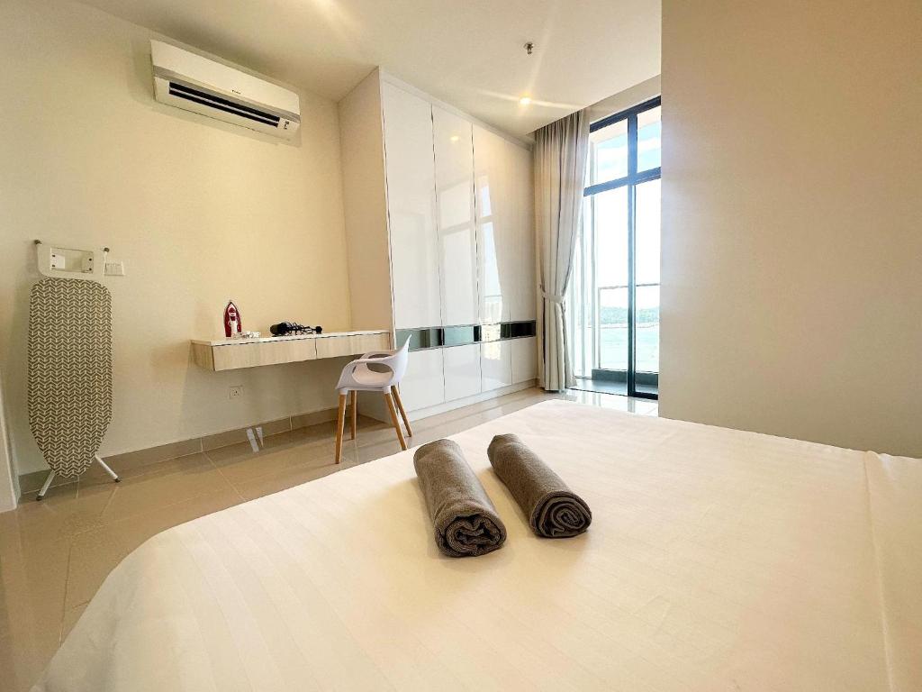 a bedroom with a bed with two pillows on it at The Shore LW Premium Suites KK Downtown in Kota Kinabalu