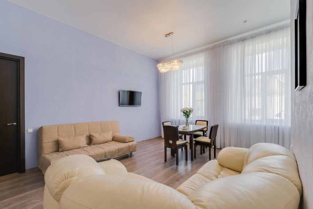 聖彼得堡的住宿－盧斌世特納9號迎賓公寓，客厅配有沙发和桌子