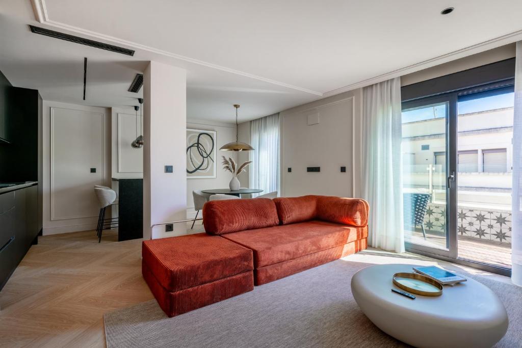 a living room with a couch and a table at Suite Plaza Nueva in Seville
