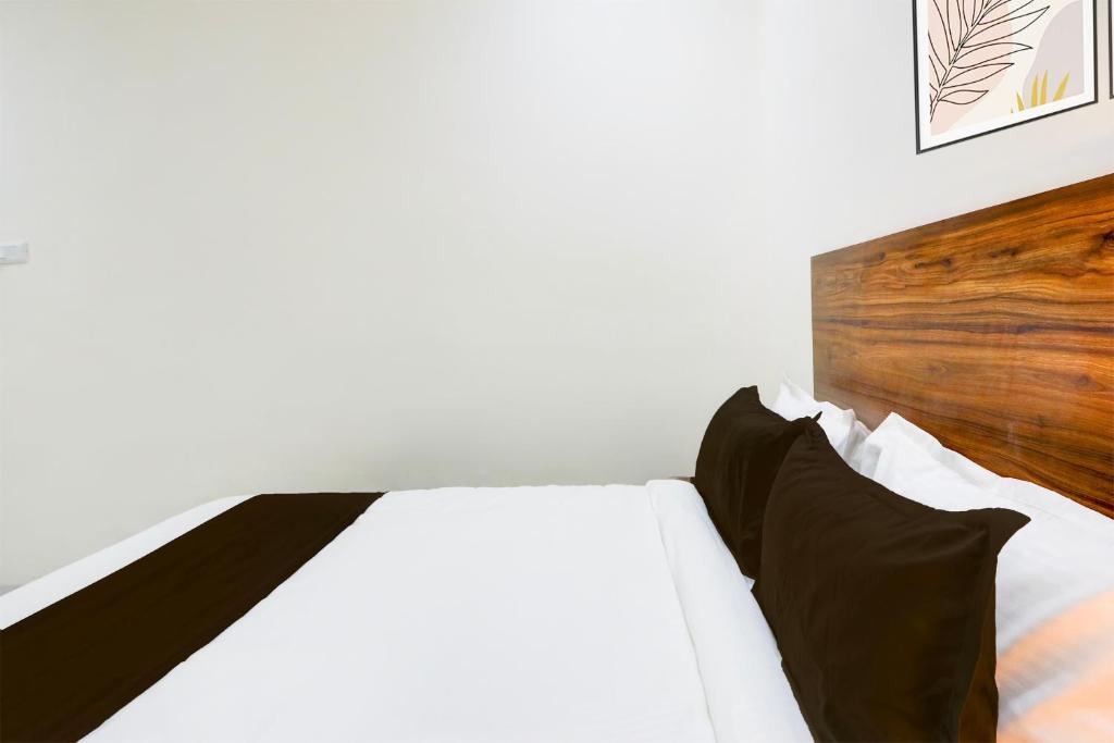 a bedroom with a white bed with a wooden headboard at Super Collection O SS BLUE INN in Hyderabad