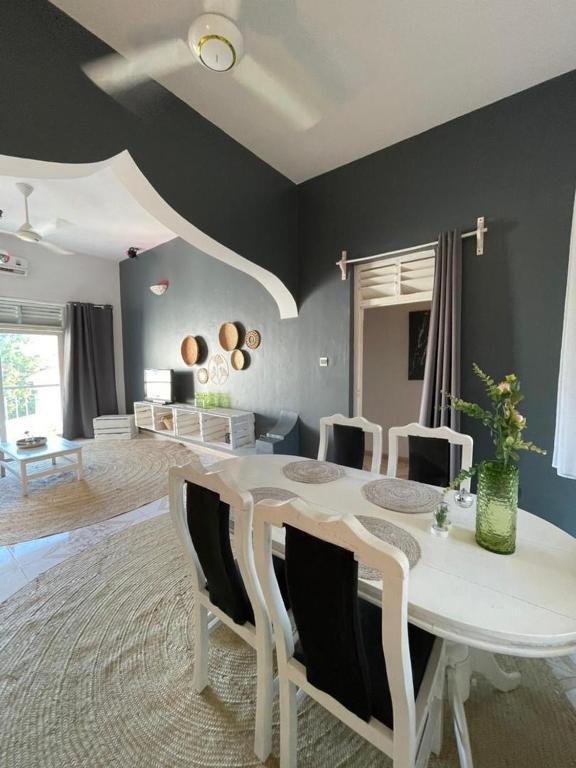 a dining room with a white table and chairs at B4 Apartment Stone Town in Zanzibar City
