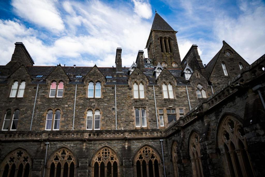 een groot bakstenen gebouw met een klokkentoren bij Moat House 6 in Fort Augustus