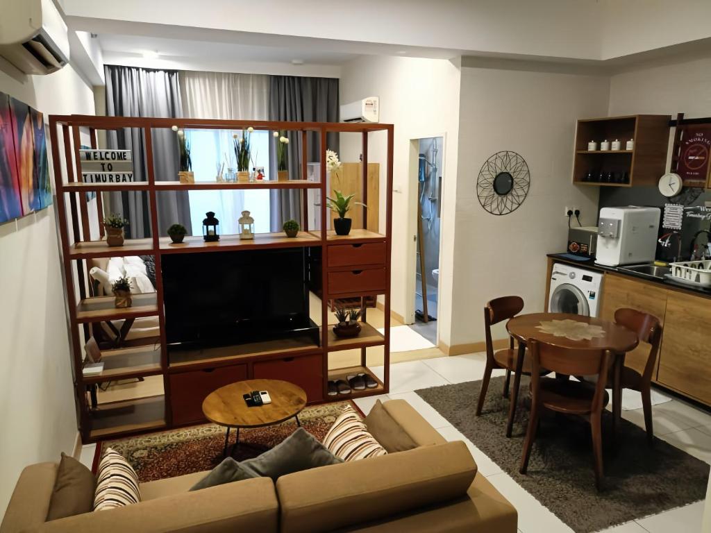 a living room with a couch and a tv and a table at Timurbay Residence Resort Style in Kuantan