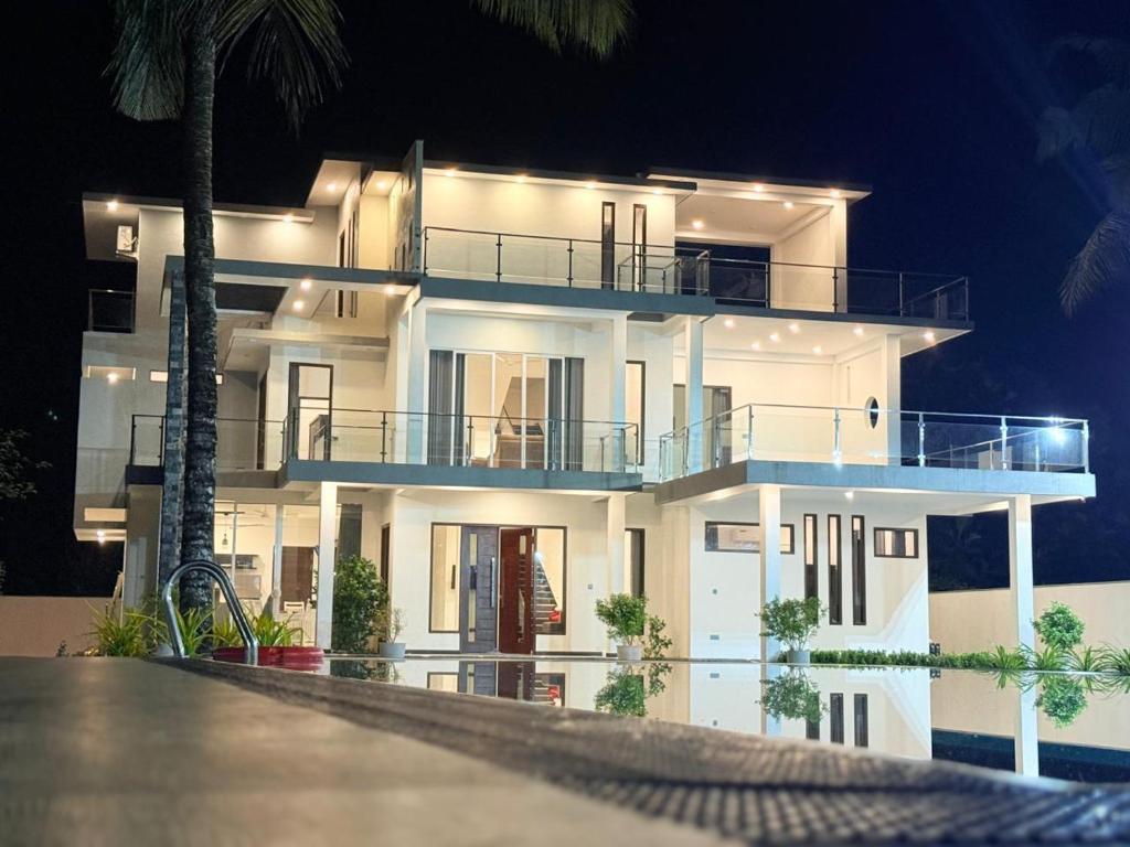 a large white house with a balcony at night at Shrek Villa in Balapitiya
