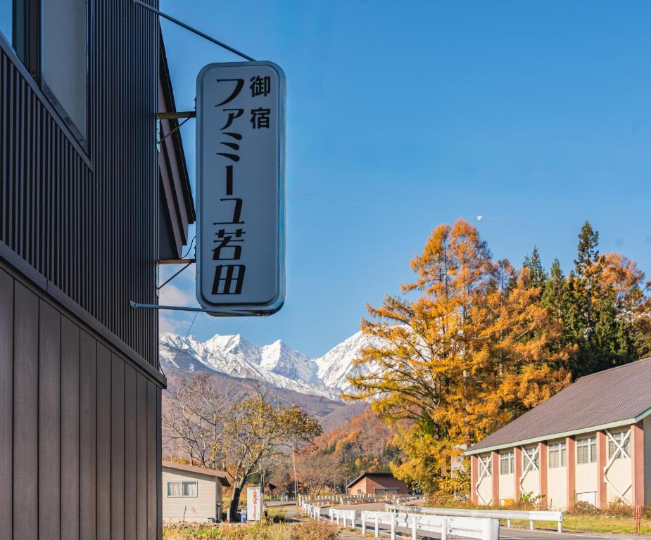een bord voor een restaurant met bergen op de achtergrond bij Wakata Lodge Hakuba - 2025 Upgrade in Hakuba