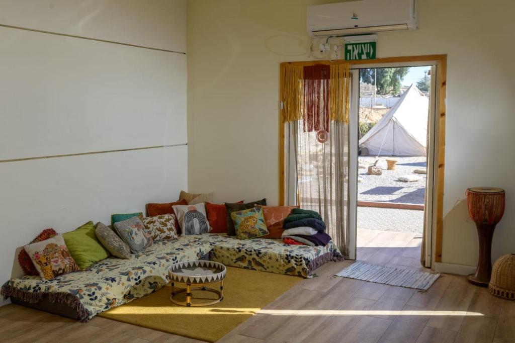 a living room with a couch and a table at Hippie House היפי האוס in Mitzpe Ramon