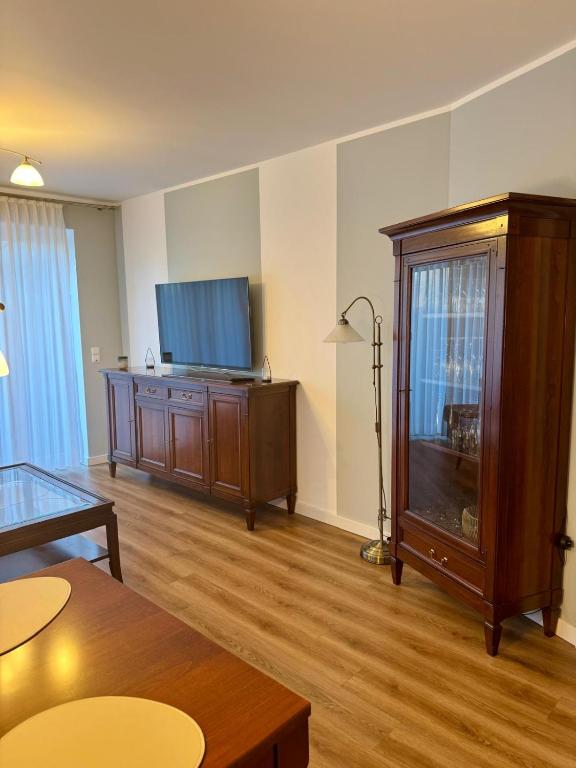 a living room with a tv and a entertainment center at Schöne Wohnung 1 in Buchholz in der Nordheide