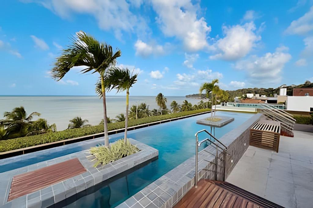 a swimming pool with a view of the ocean at Unity - Flat Premium à Beira-Mar em Cabo Branco in João Pessoa