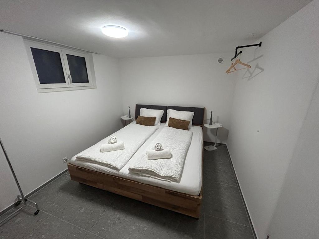 a bedroom with a bed in a white room at Gemütliche Souterrainwohnung mit gratis Parkplatz in St. Gallen