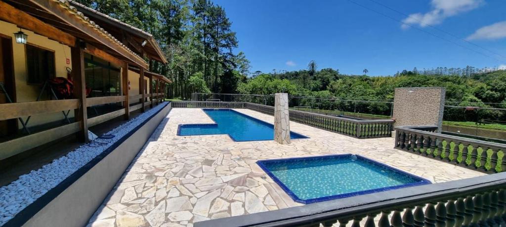 a house with two swimming pools on a patio at Espaço Villa Verde in Ibiúna