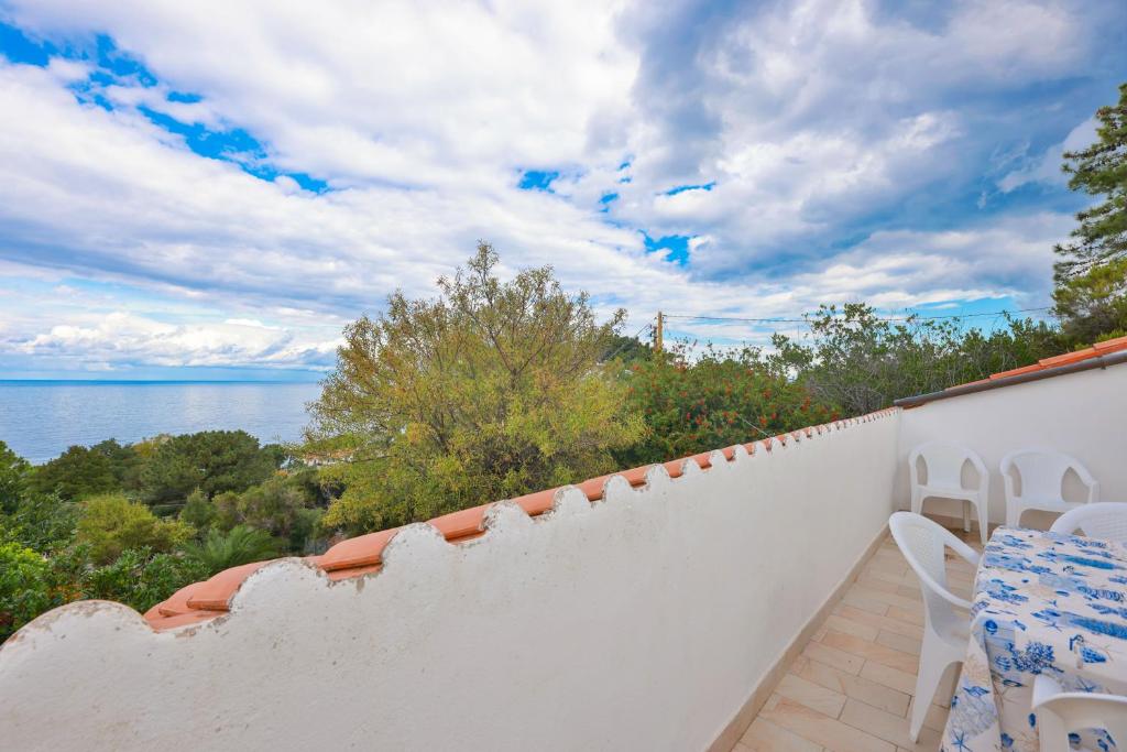 valla blanca con mesa y sillas en el balcón en Cotoncello in una posizione panoramica - Goelba, en Marciana