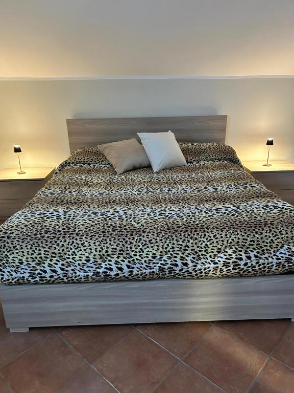 a bed with a black and white comforter and two pillows at Eden Apartment di Manenti Andrea in Oltre il Colle