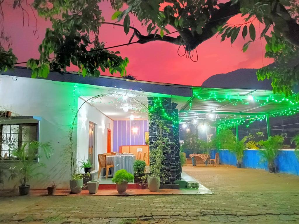 una casa con luces verdes encendidas por la noche en NK Hotel & Resturaunt, en Matale
