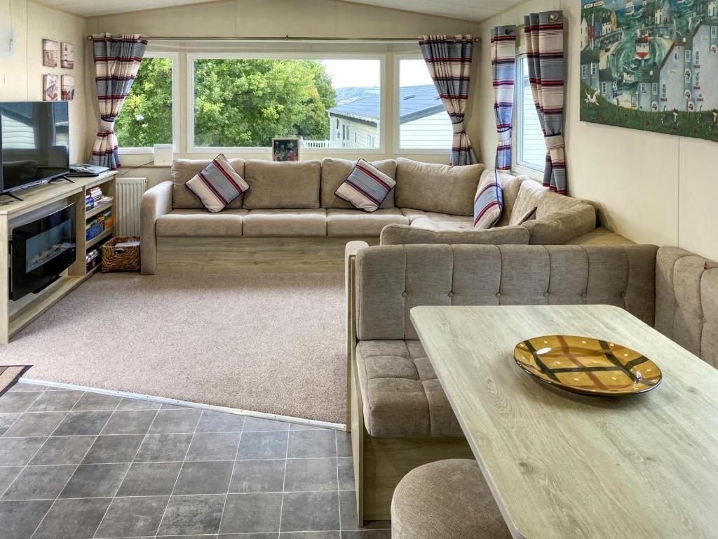 Una sala de estar con dos sofás y una mesa. en Lapras, en Porchfield