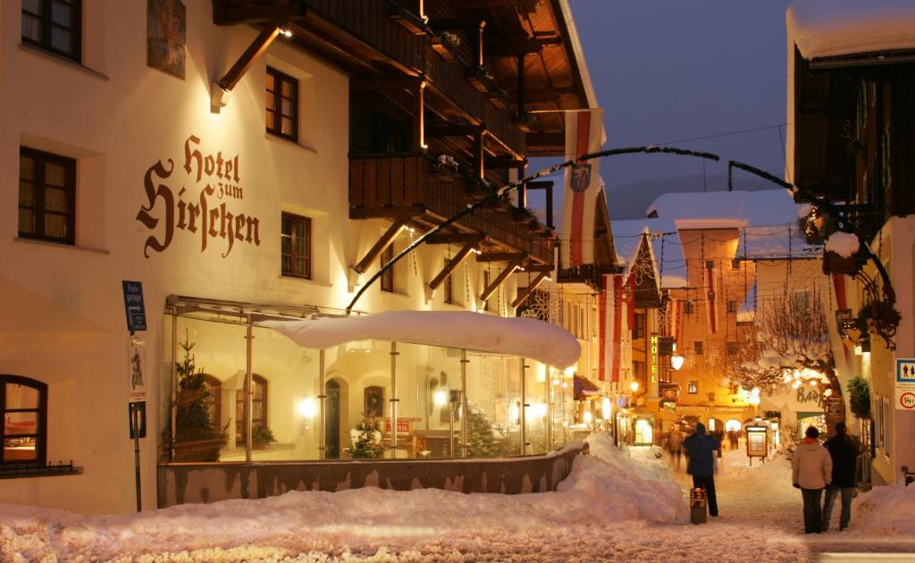 people walking down a snow covered street at night at Hotel zum Hirschen in Zell am See