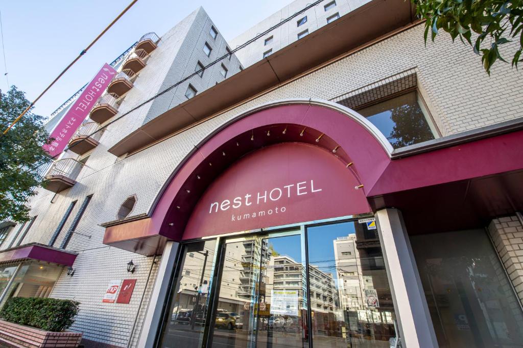 fachada de um hotel da rede Nest em uma rua da cidade em Nest Hotel Kumamoto em Kumamoto