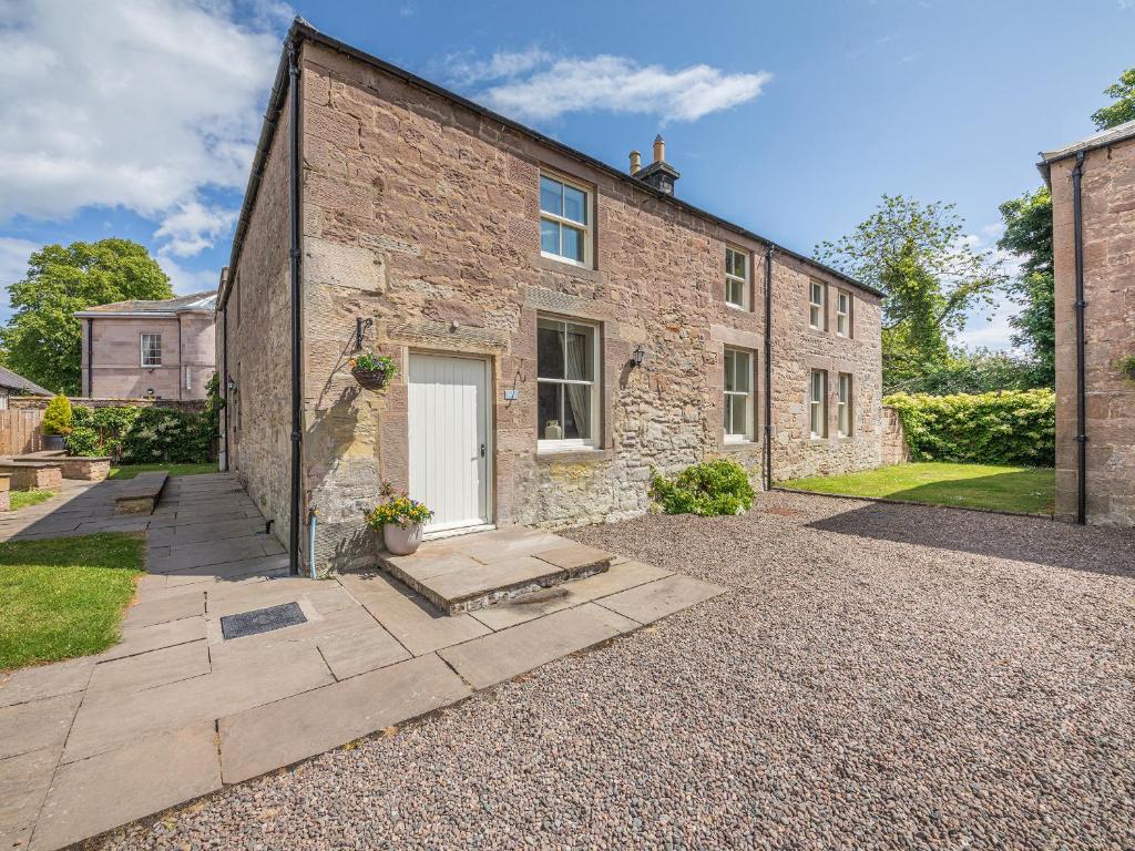 ein Backsteinhaus mit einer weißen Tür und einem Hof in der Unterkunft Swinney Cottage - Uk49893 in Preston