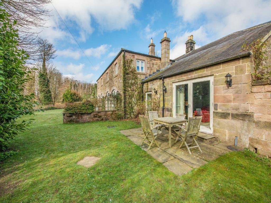 a stone house with a table and chairs in the yard at Longlands - Uk49289 in Preston