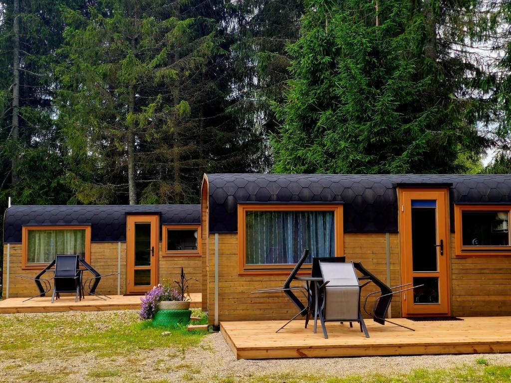 ein kleines Haus mit zwei Stühlen auf einer Terrasse in der Unterkunft Brīvdienu namiņi Kalnozoli in Indrāni
