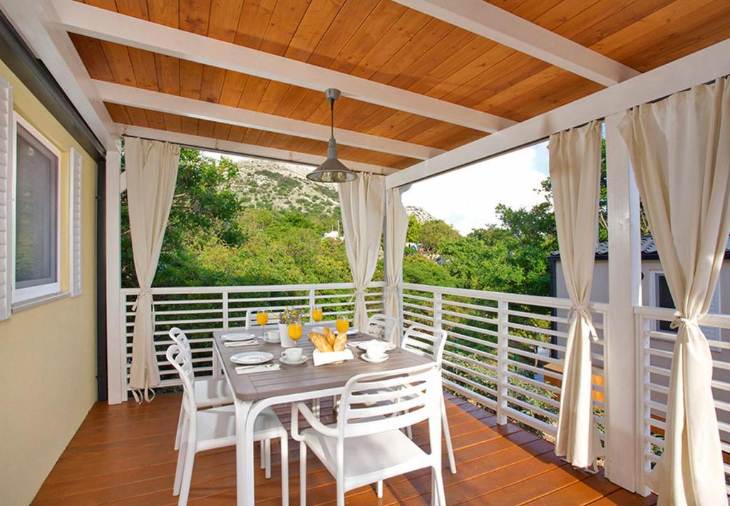 a porch with a table and chairs on a balcony at Valamar Camping Lanterna - Adriacamps in Poreč