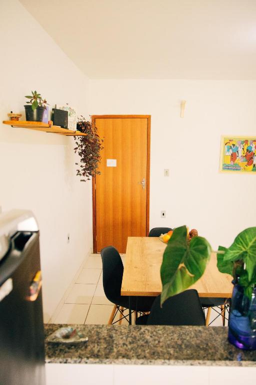 Habitación con mesa, sillas y puerta de madera. en Casa Dengo - Quarto Aconchegante, en Ouro Preto