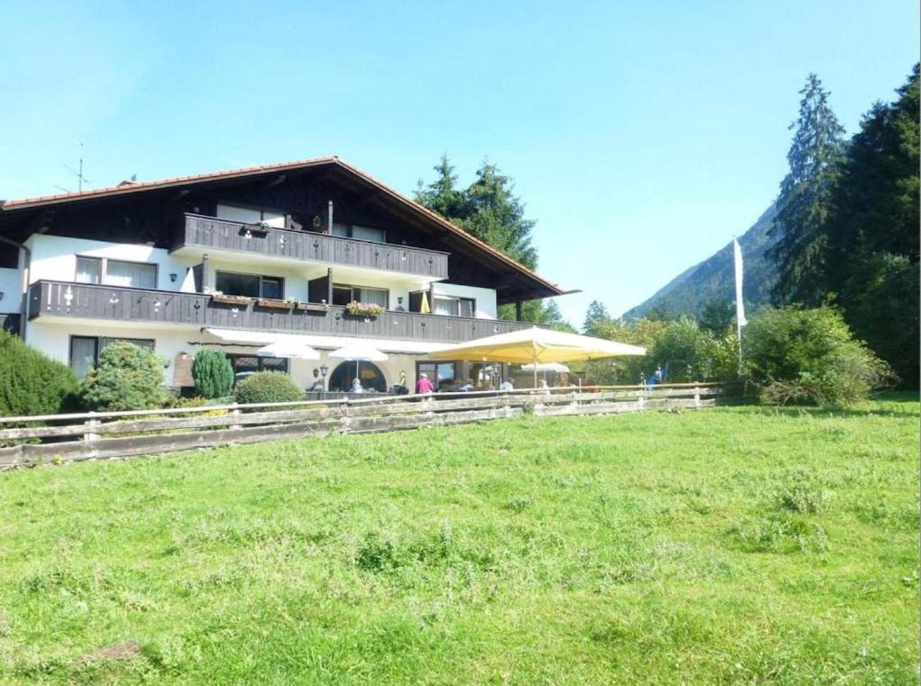 a large building with a grass field in front of it at Zugspitz Traumapartment in Farchant