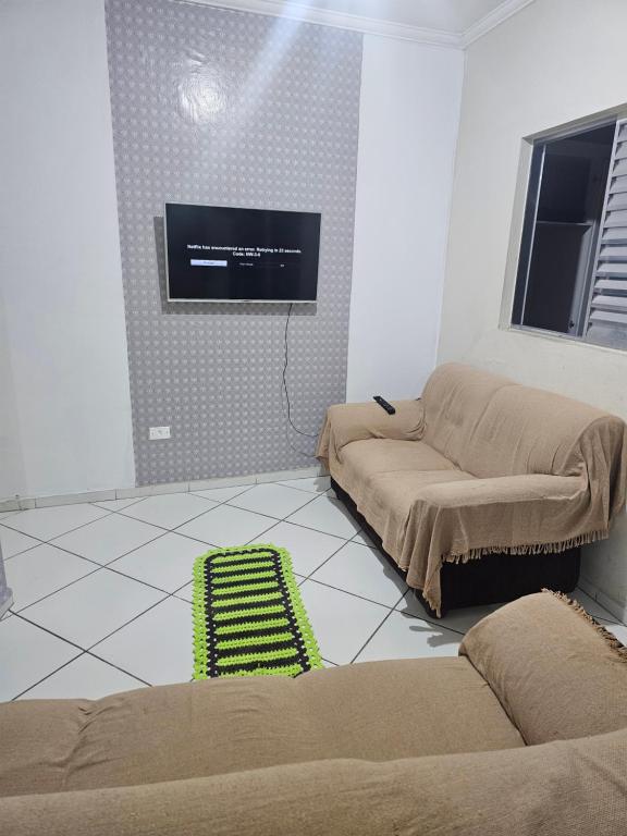 a living room with two couches and a flat screen tv at Itapecerica da Serra perto de Embu das artes e Cotia in Itapecerica da Serra