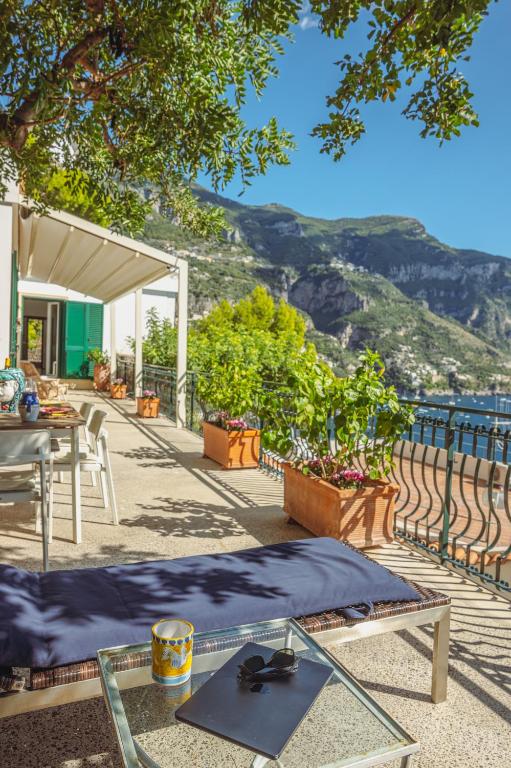 a patio with a table and a view of the mountains at POSEA Collection - Villa La Nice in Positano